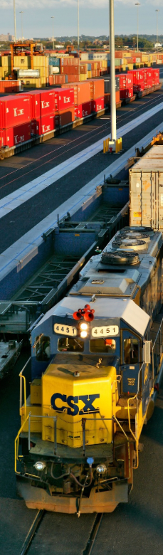 Rail freight train transporting shipping containers through a port terminal in Australia.